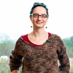 Image of a woman with glasses and earrings and a man with a moustache, shirt and jacket