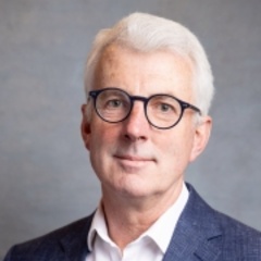 Head and shoulder shot of man in shirt and jacket with glasses