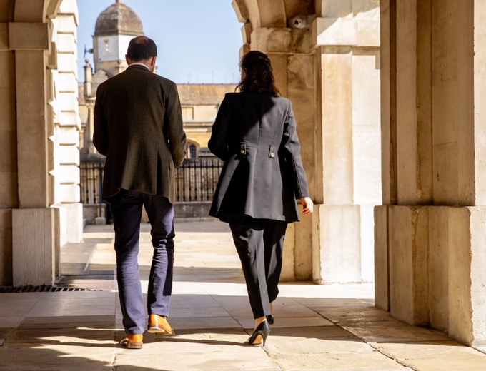 Two staff members walking, with their backs to the camera